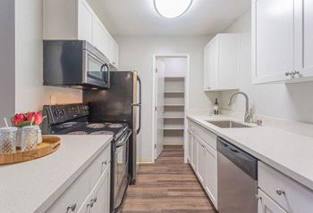 a kitchen with white cabinets and a black refrigerator  at Skyline Heights LLC, Daly City, CA